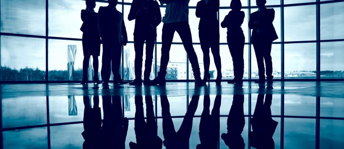 Business team standing against window with leader in front